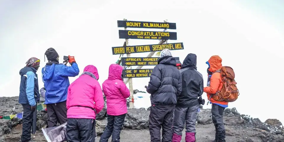 A group of climbers at the summit signpost