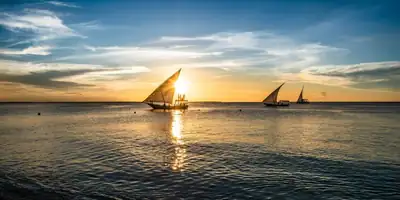 Dhows sailing towards the setting sun