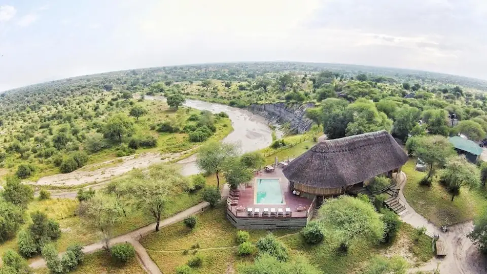 Aerial view of Mbali Mbali Tarangire River Camp, its thatched lounge and pool above a dry river bed